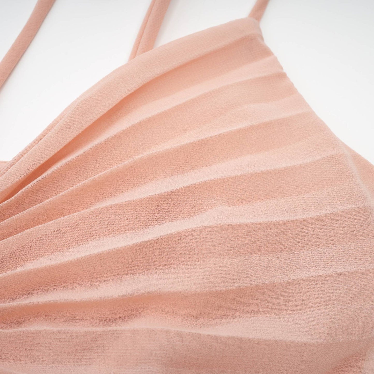 Woman wearing a pink pleated tiered midi dress with flowy silhouette