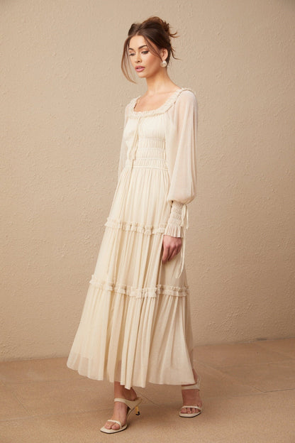 Woman wearing a pleated metallic midi dress with shirred detailing and a flowy silhouette named Camille