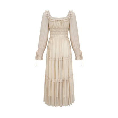 Woman wearing a pleated metallic midi dress with shirred detailing named Camille