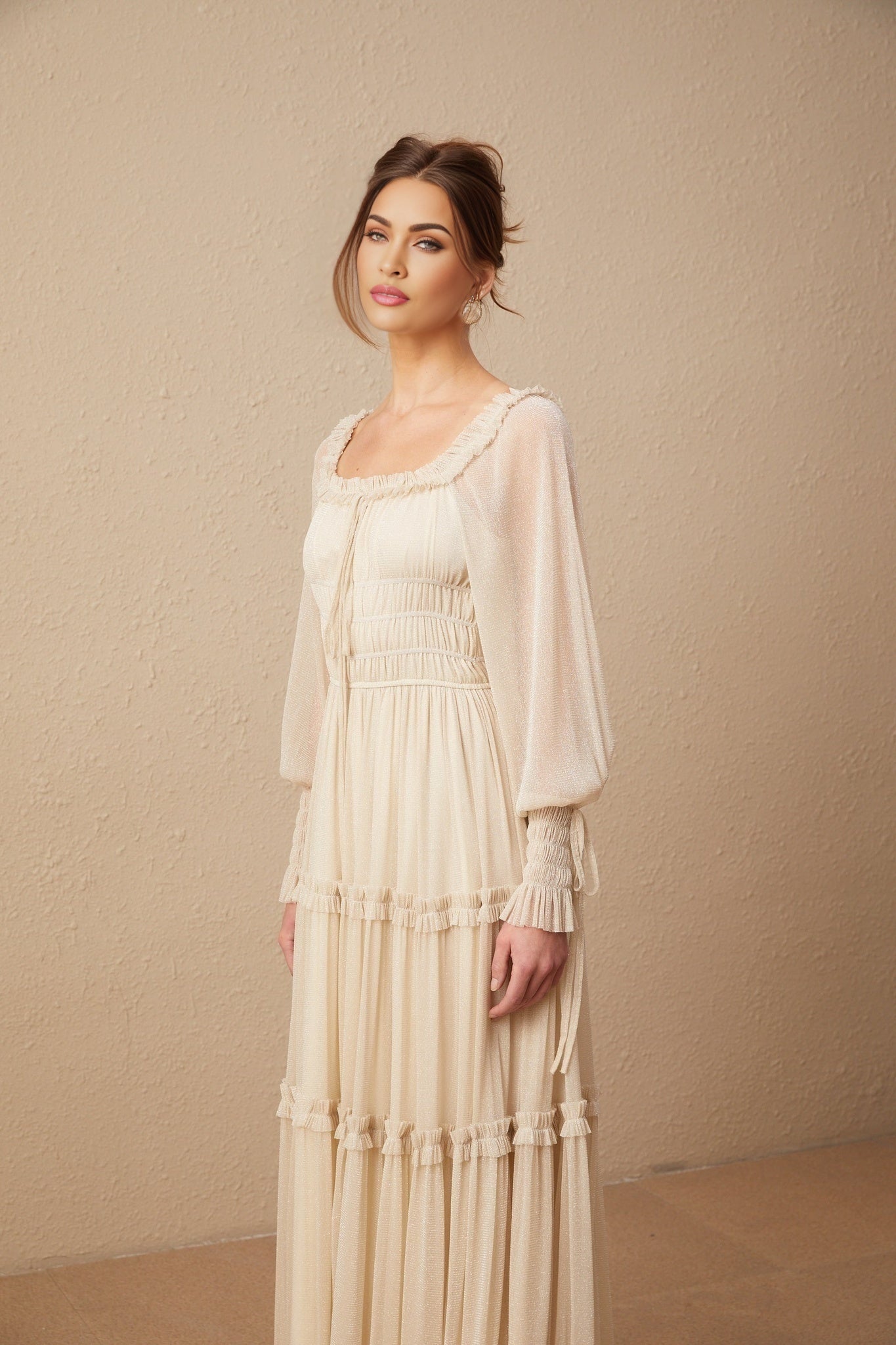Woman wearing a pleated metallic midi dress with shirred detailing named Camille