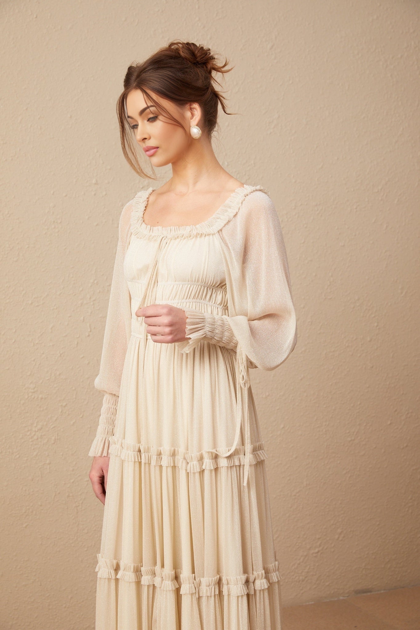 Woman wearing a pleated metallic midi dress with shirred detailing named Camille