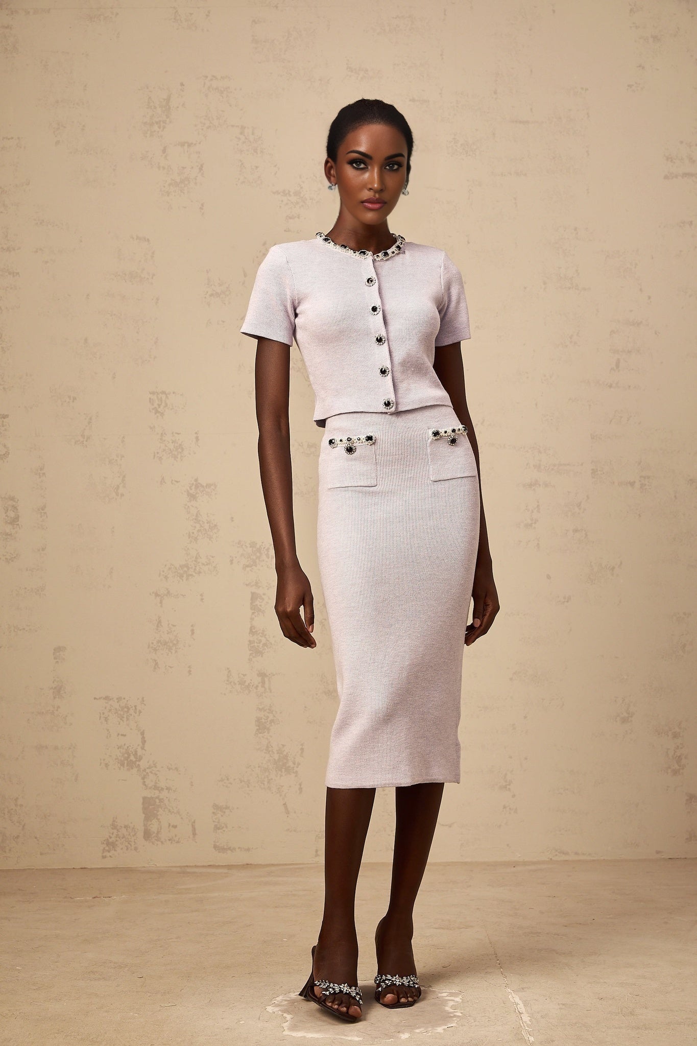 Woman wearing a purple knit top and matching skirt set with beaded details named Abbie
