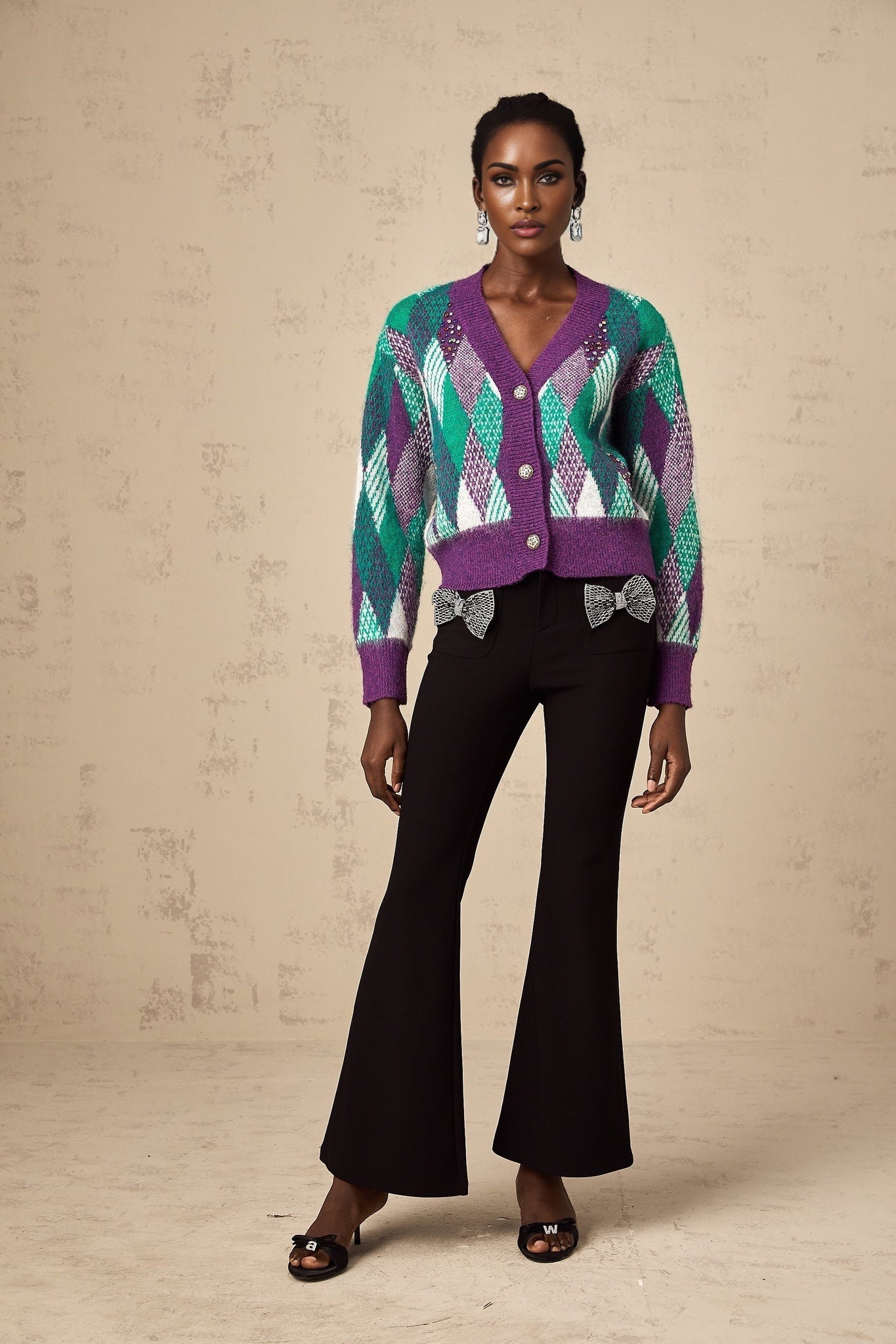 Woman wearing a purple knit top with argyle pattern design