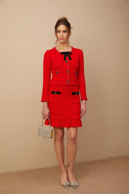 Woman wearing a red braided waffle knit jacket and matching skirt set named Cynthia