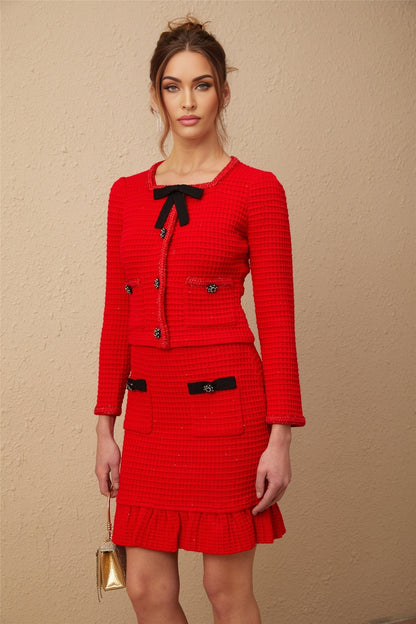 Woman wearing a red braided waffle knit jacket and matching skirt set named Cynthia