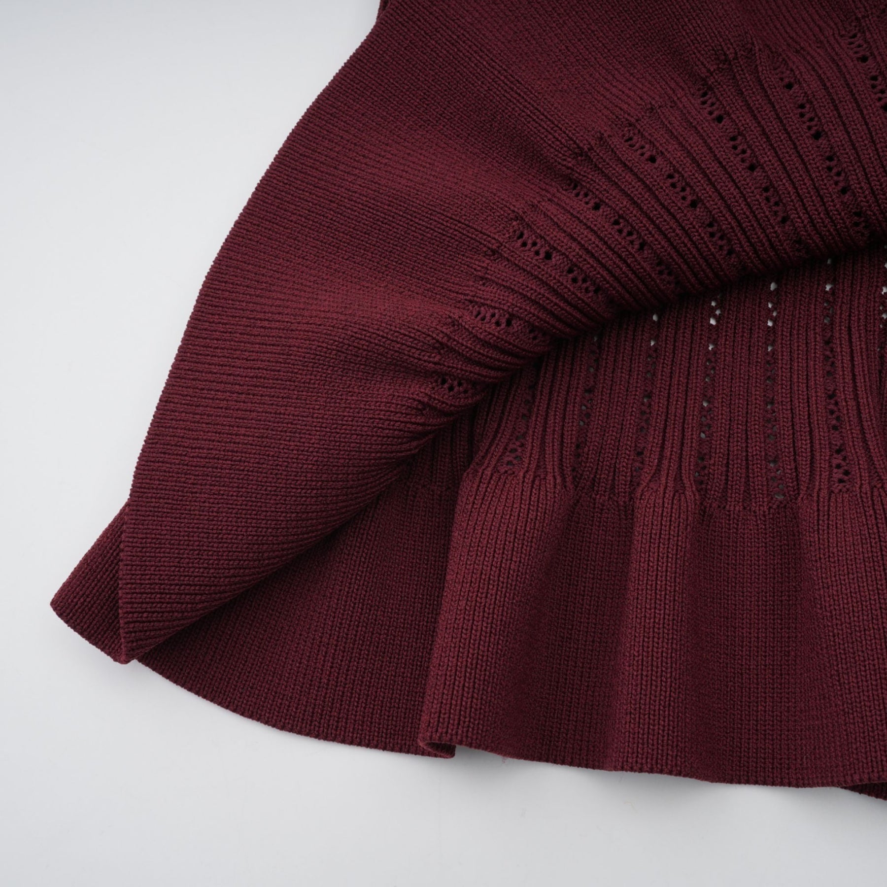 Woman wearing a red knit matching set with ruffled top and skirt named Corrine
