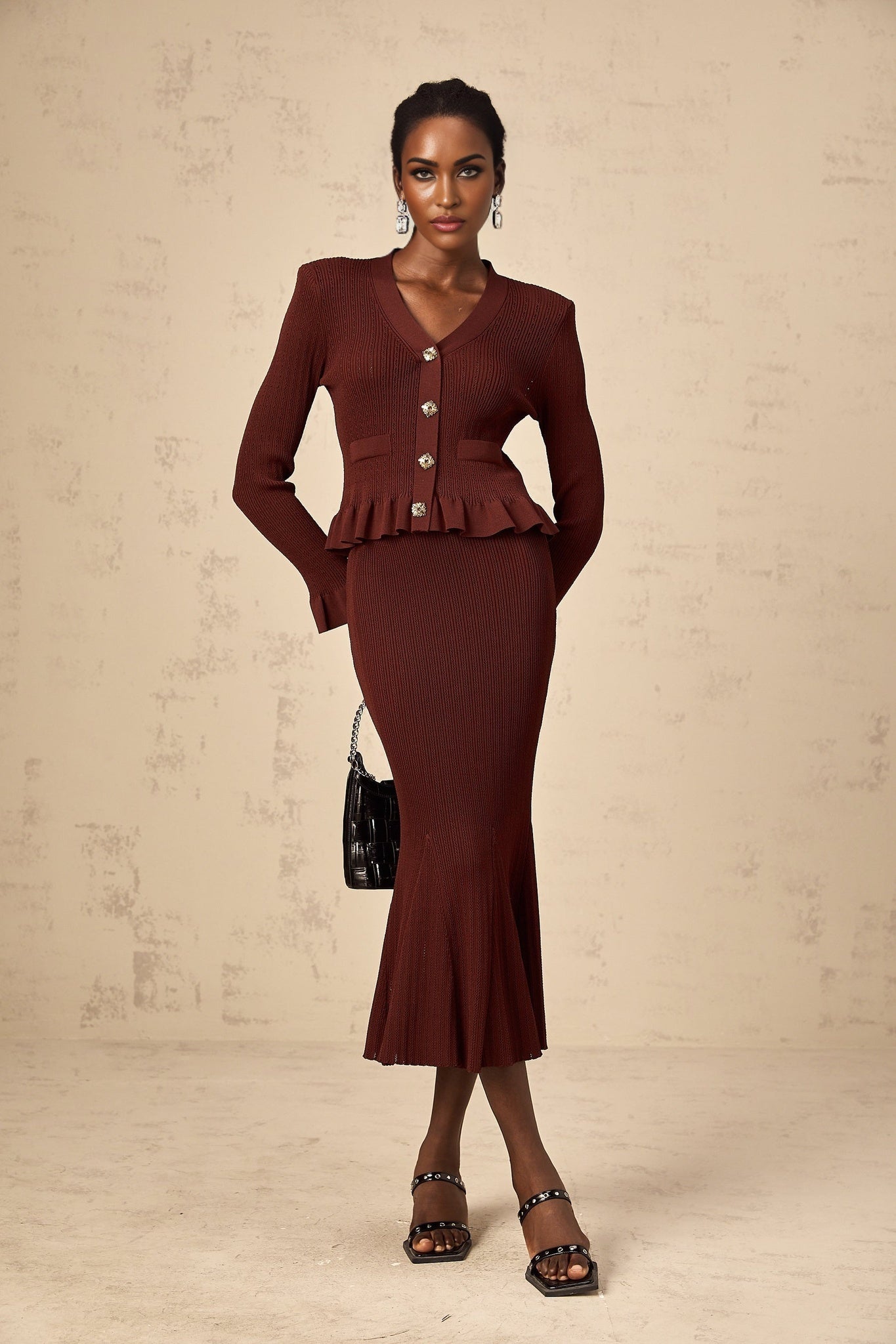 Woman wearing a red knit matching set with ruffled top and skirt