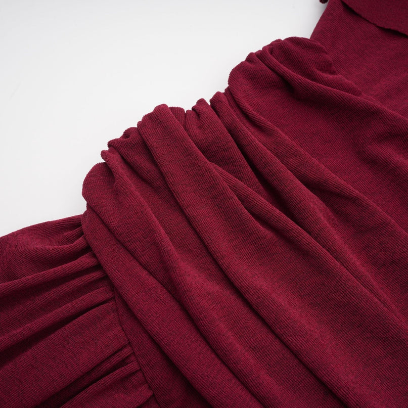 Woman wearing a red midi dress with ruched details and a flap design on the bodice