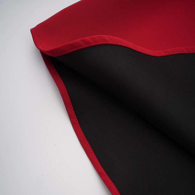 Woman wearing a red pleated blouse and matching skirt set called Colette The blouse has a flowy design with pleats and the skirt features a high waist and pleated fabric