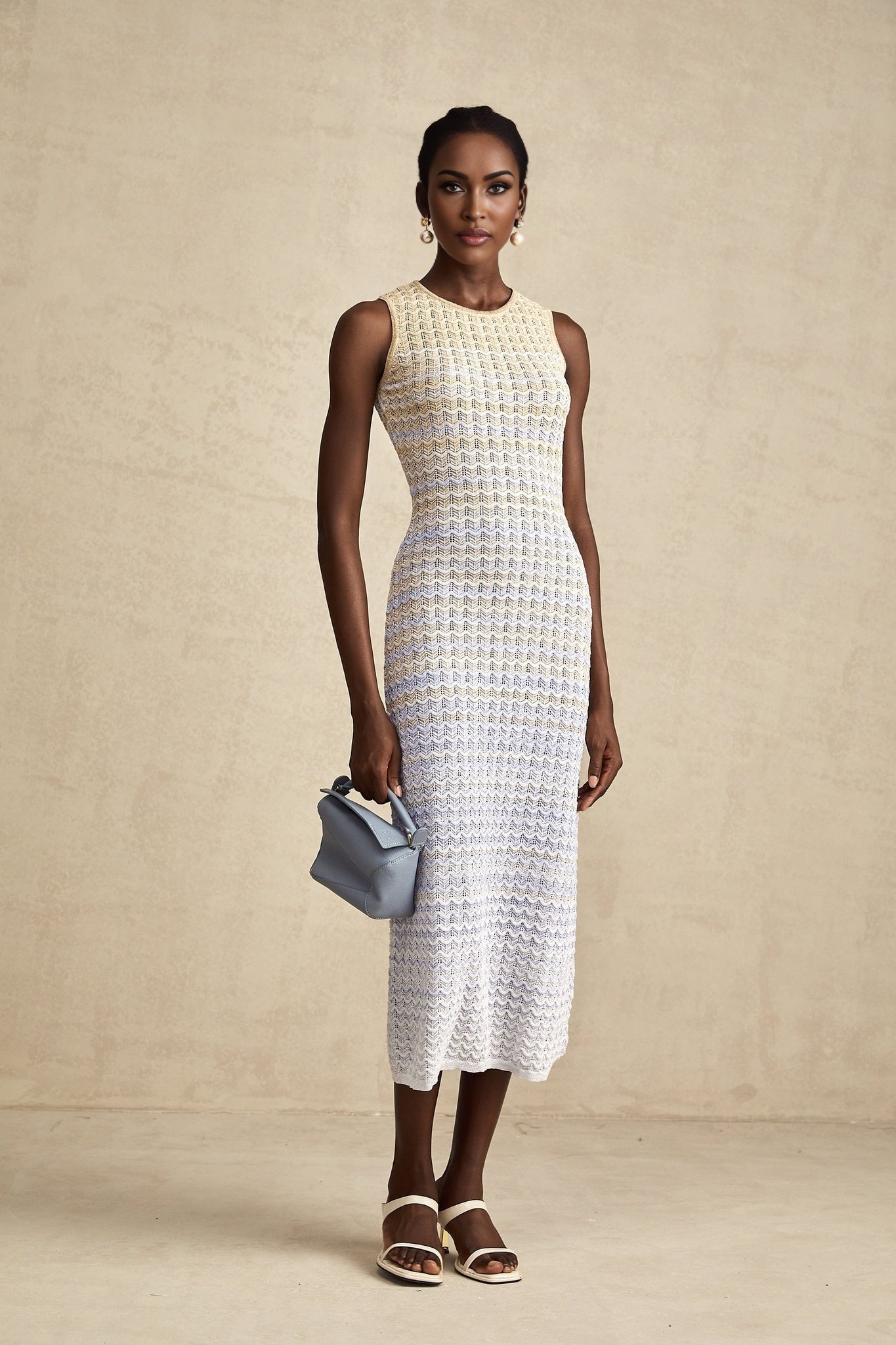 Woman wearing a ribbed knit midi dress with contrasting color details and a fitted silhouette
