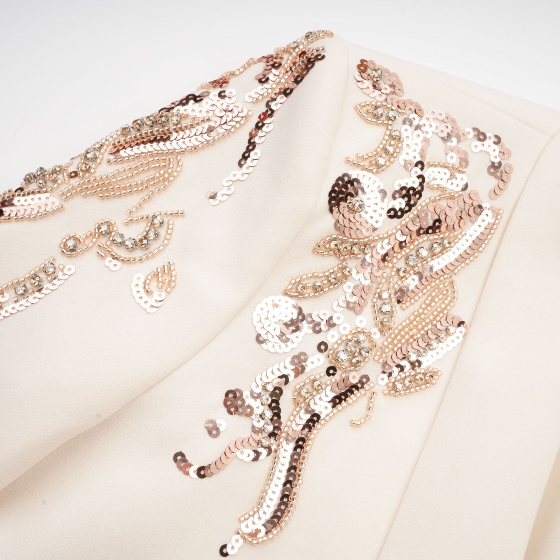 Woman wearing a shimmering blazer dress covered in sequins with embellished details