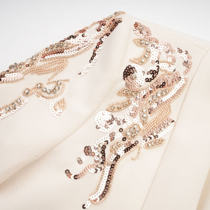 Woman wearing a shimmering blazer dress covered in sequins with embellished details