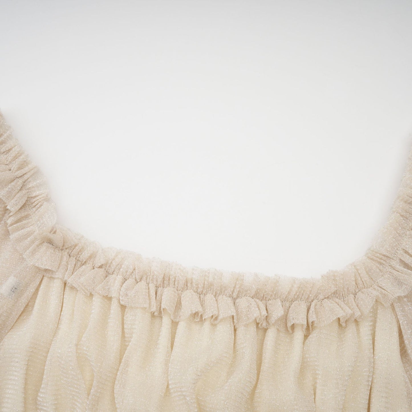 Woman wearing a shimmering pleated midi dress with shirred detailing and metallic finish in a soft flowing silhouette
