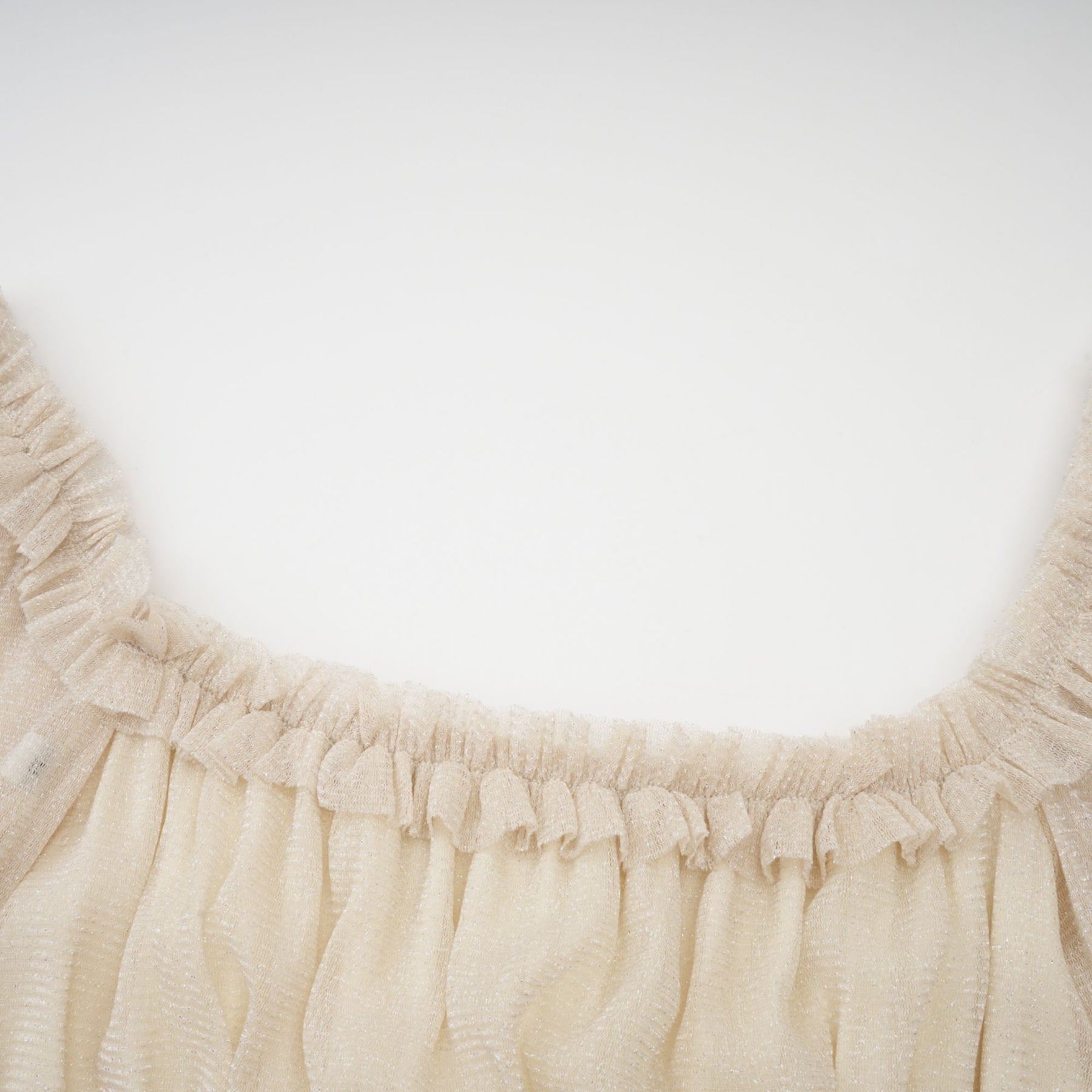Woman wearing a shimmering pleated midi dress with shirred detailing and metallic finish in a soft flowing silhouette