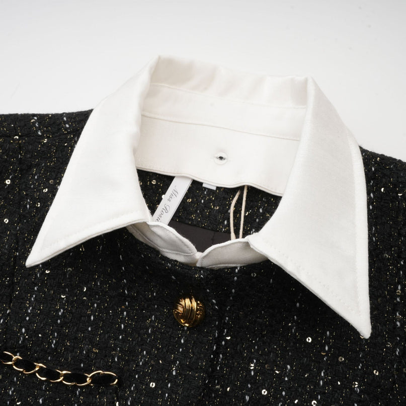 Woman wearing a short black dress with tweed fabric and sequin panels featuring a sleeveless design and fitted silhouette