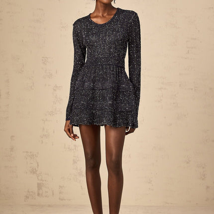 Woman wearing a short black knitted dress with sequin embellishments form fitting silhouette and mini length