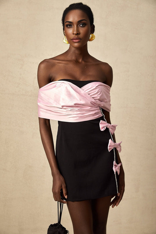 Woman wearing a short colorblocked dress with a bow detail