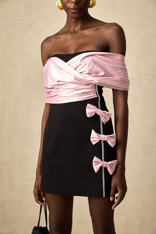 Woman wearing a short colorblocked dress with a bow detail