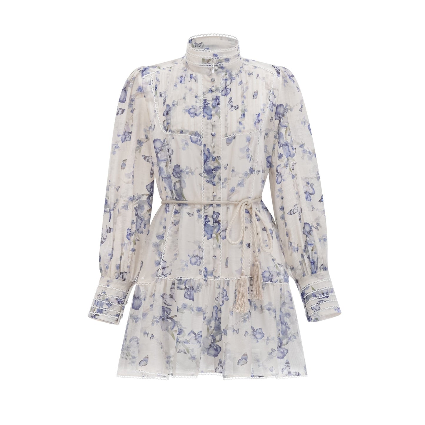 Woman wearing a short floral print dress with flared sleeves and a flowy chiffon fabric in light colors against a plain background