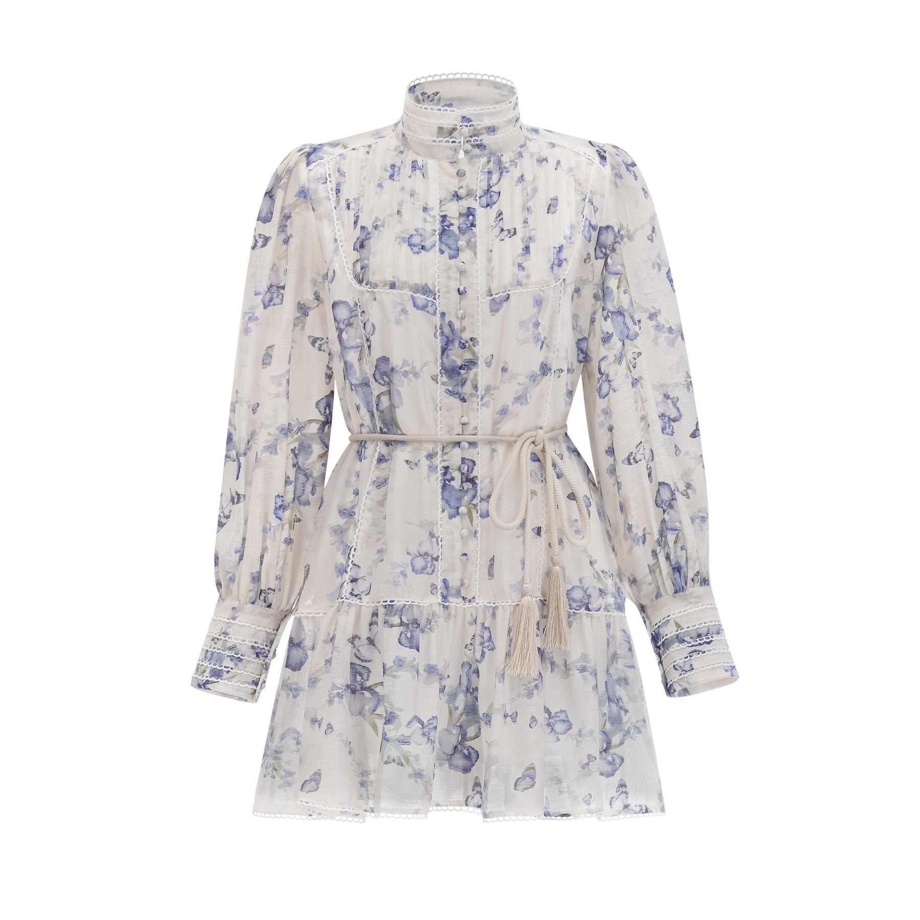 Woman wearing a short floral print dress with flared sleeves and a flowy chiffon fabric in light colors against a plain background