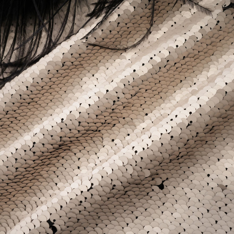 Woman wearing a short jacket with sequins and feather embellishments