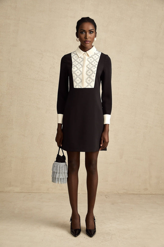 Woman wearing a short mini dress with contrasting colors and embellishments