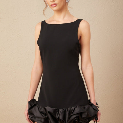 Woman wearing a short ruffled dress with an open back design