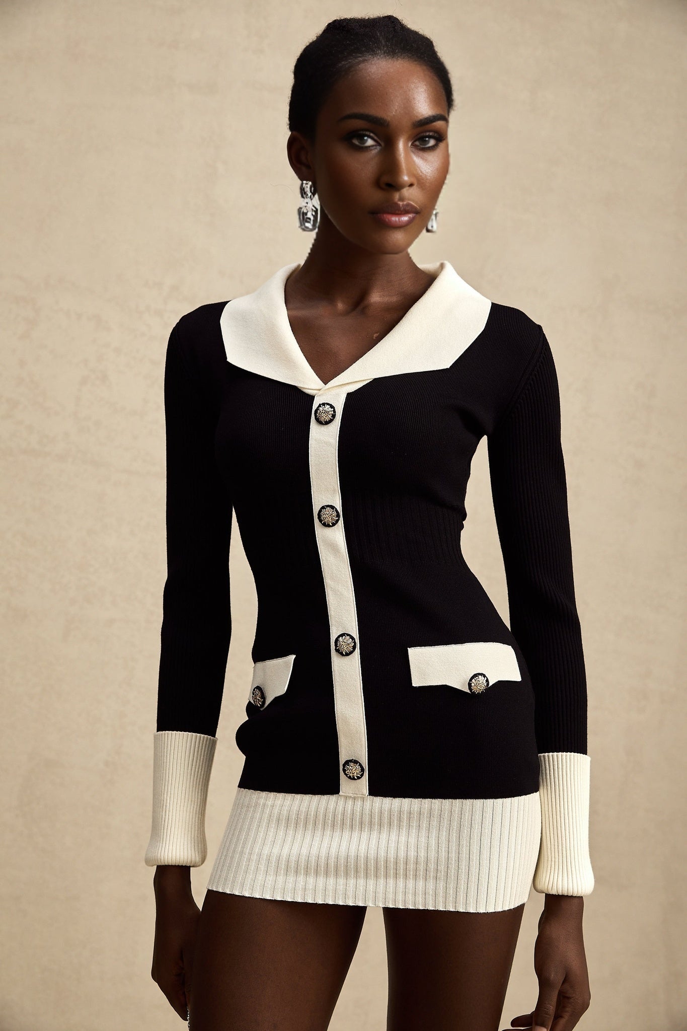 Woman wearing a short wool dress with color block design and ribbed texture featuring different colored sections