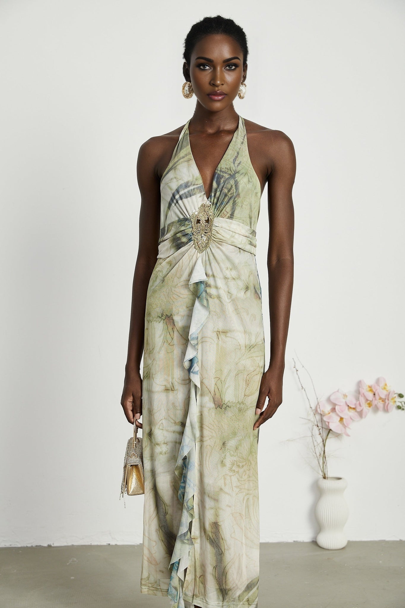Woman wearing a sleeveless midi dress with a neckholder style and ombre print pattern fading from dark to light colors