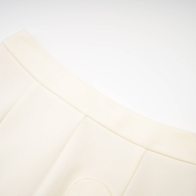 Woman wearing a sparkling crystalembellished jacket and matching shorts set in white