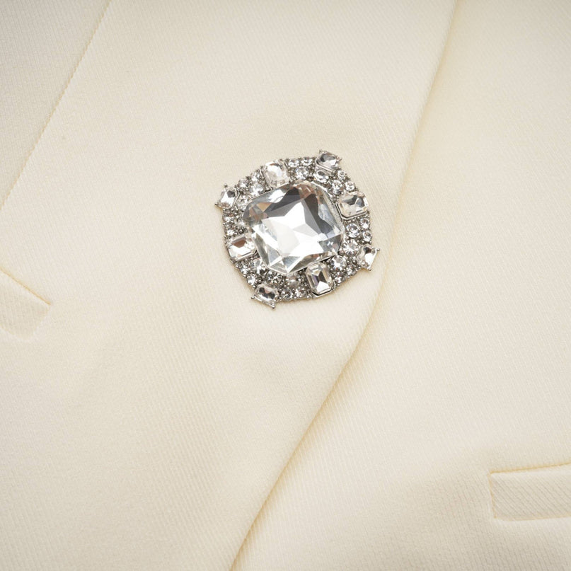 Woman wearing a sparkly jacket and matching shorts set adorned with crystal embellishments