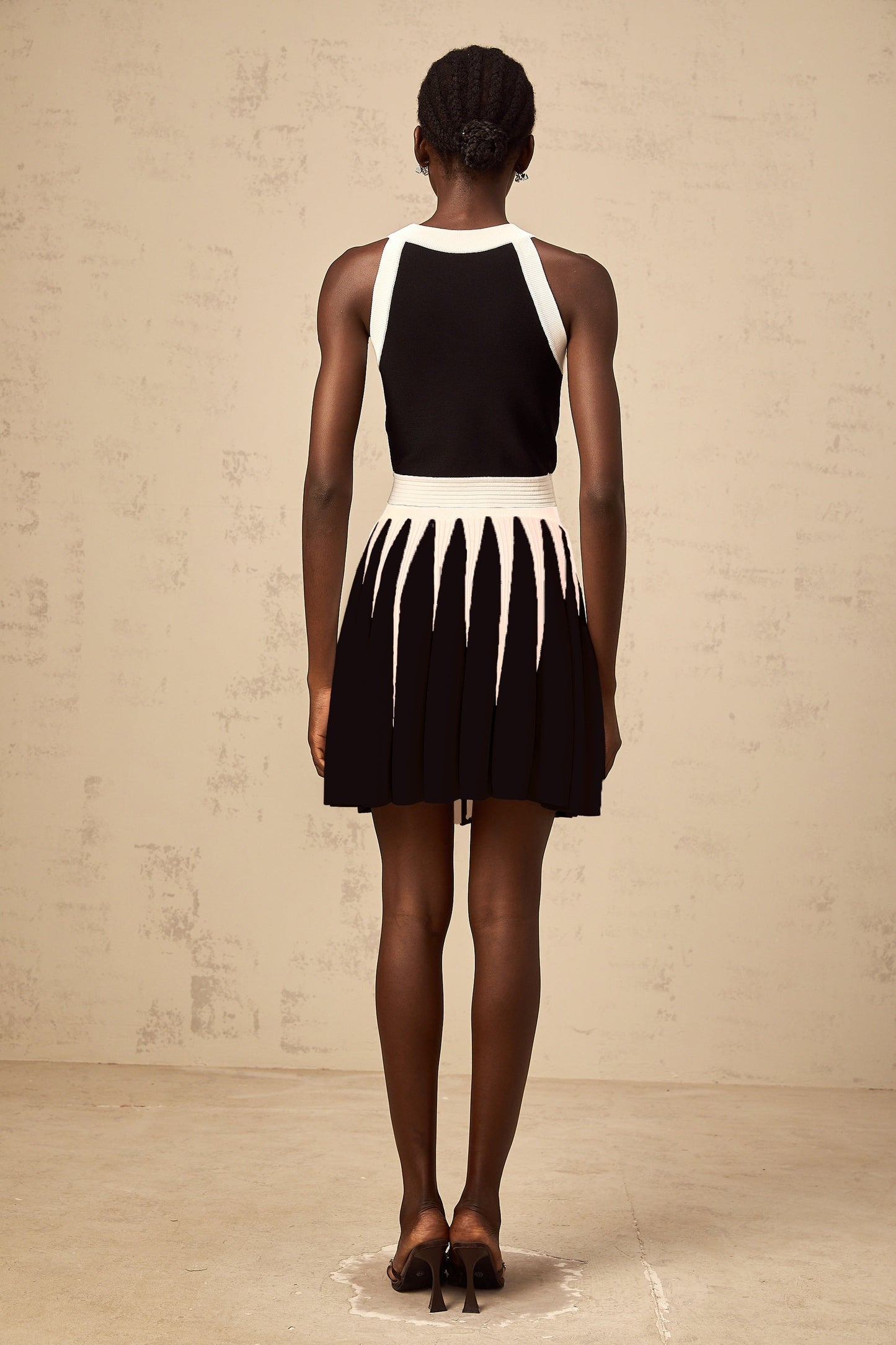 Woman wearing a striped knit top and matching skirt set in contrasting colors named Iseult