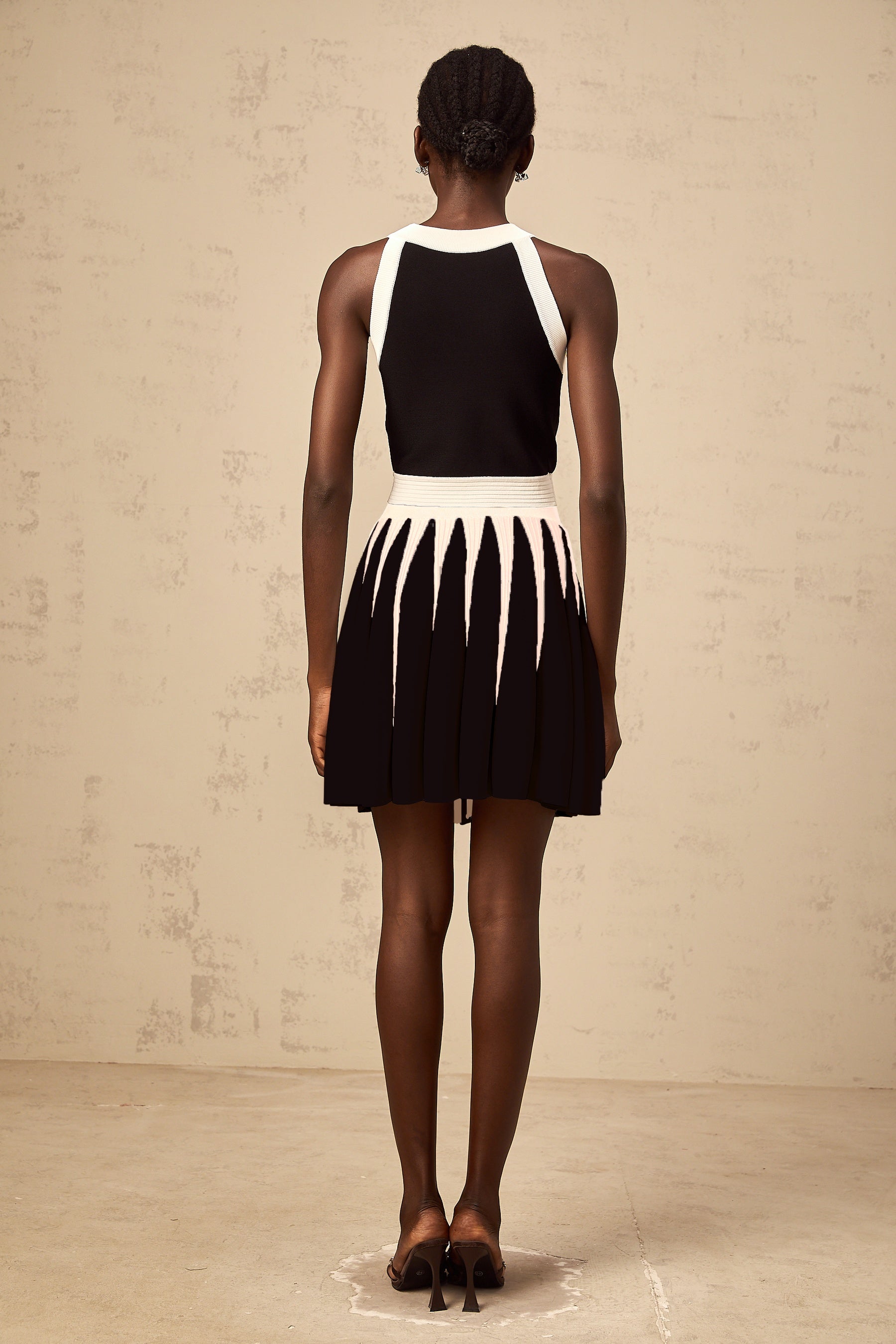 Woman wearing a striped knit top and matching skirt set in contrasting colors named Iseult