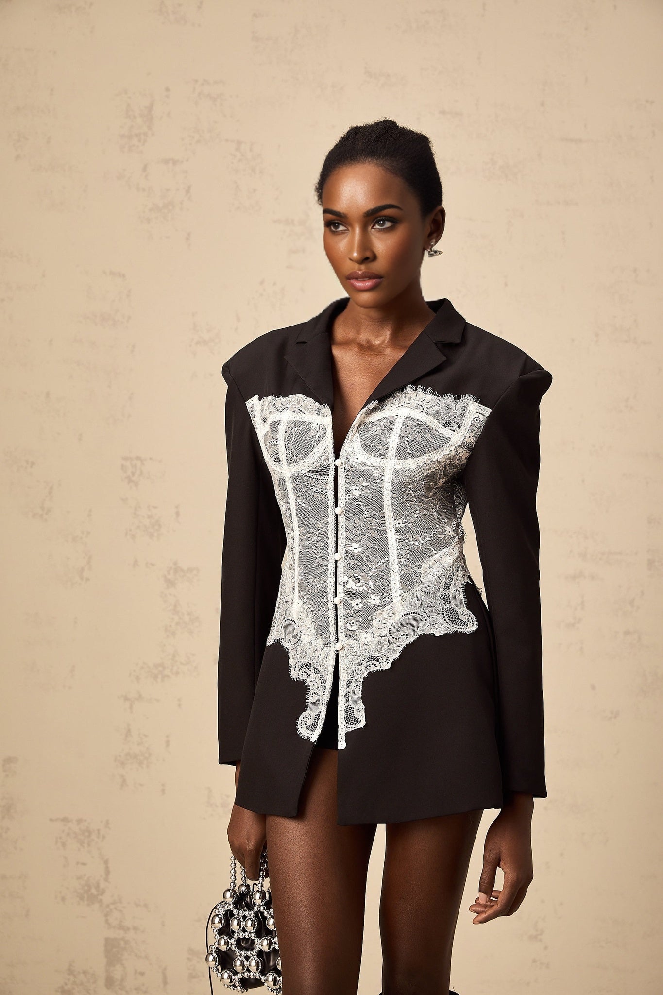 Woman wearing a stylish blazer with colorblocked design and lace panel details