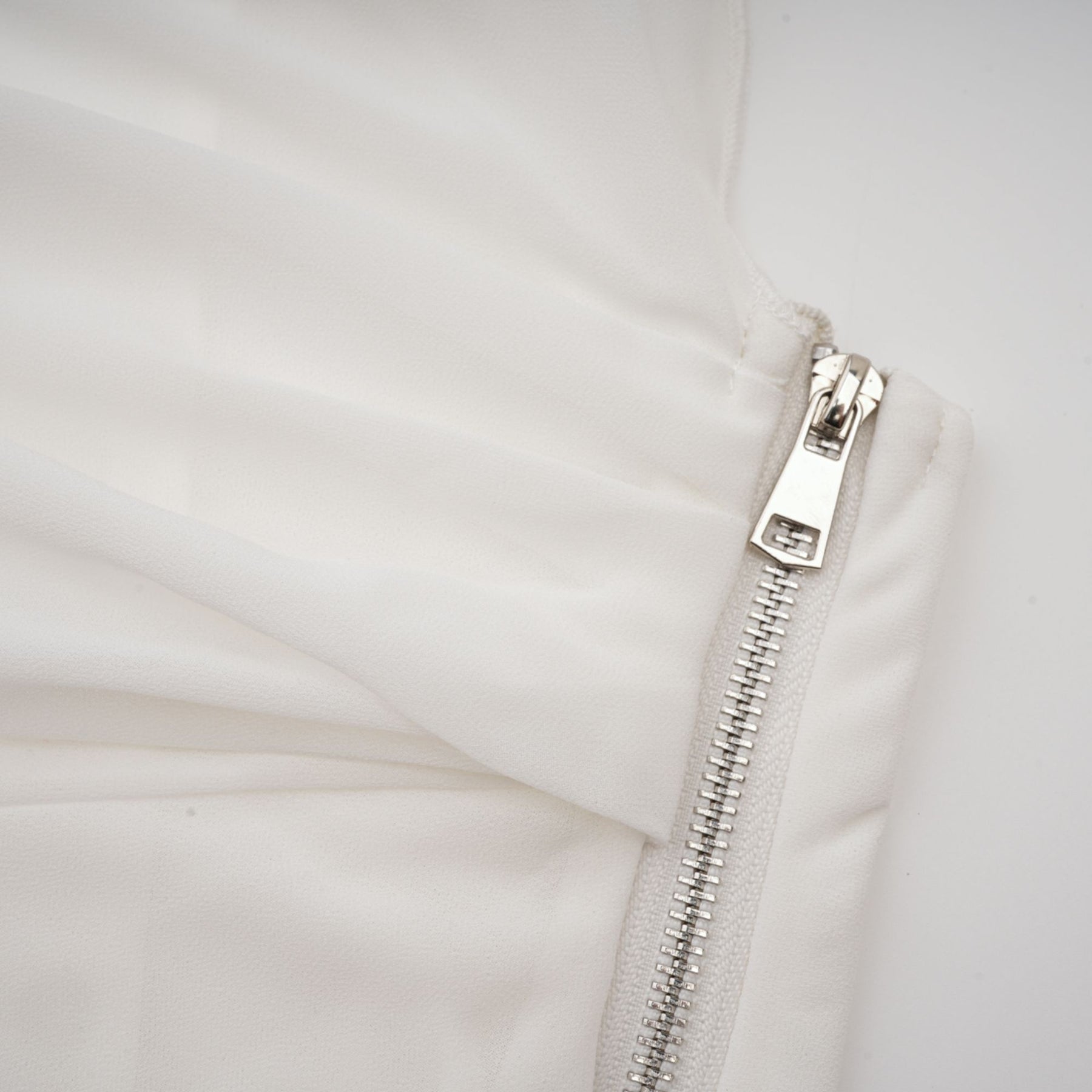 Woman wearing a white chiffon blouse with flowy fabric and delicate details