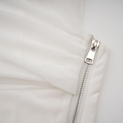 Woman wearing a white chiffon blouse with flowy fabric and delicate details