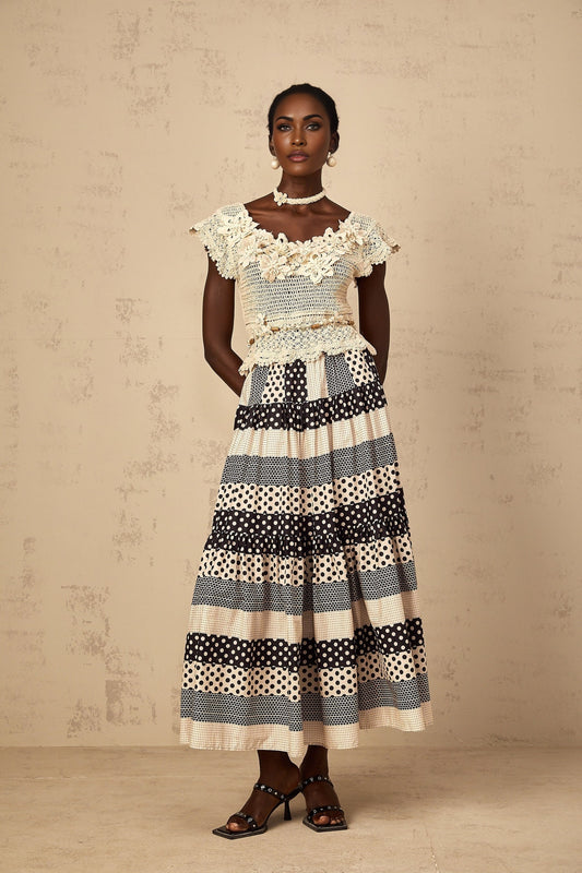 Woman wearing a white crochet knit top with three dimensional floral beaded details