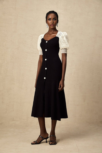 Woman wearing a white knit midi dress with lace trim details along the neckline and hem standing in a neutral background