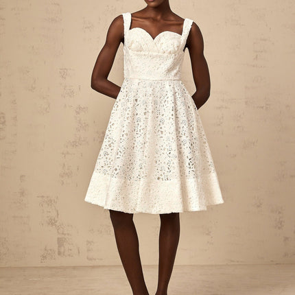 Woman wearing a white midi dress with floral lace pattern and sleeveless design