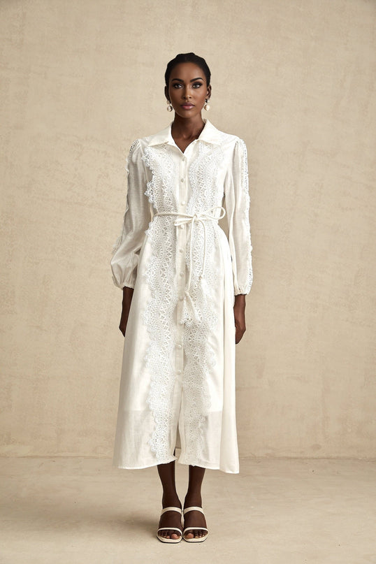 Woman wearing a white midi dress with lace details and a tied waist