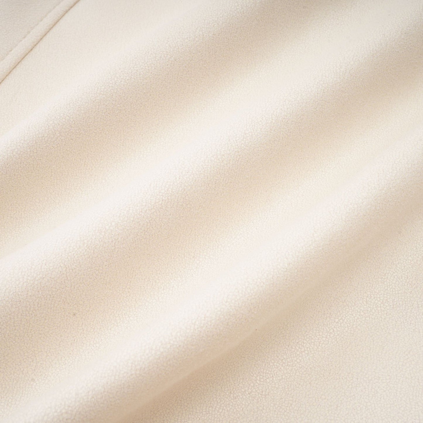 Woman wearing a white short coat made of suede with fur trim and padded design