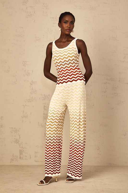 Woman wearing a yellow zigzag pattern knit top and matching bottoms standing in a relaxed pose