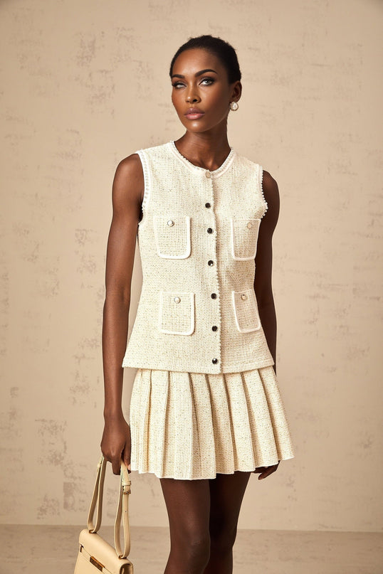 Woman wearing beige knit vest top and matching skirt adorned with sequins