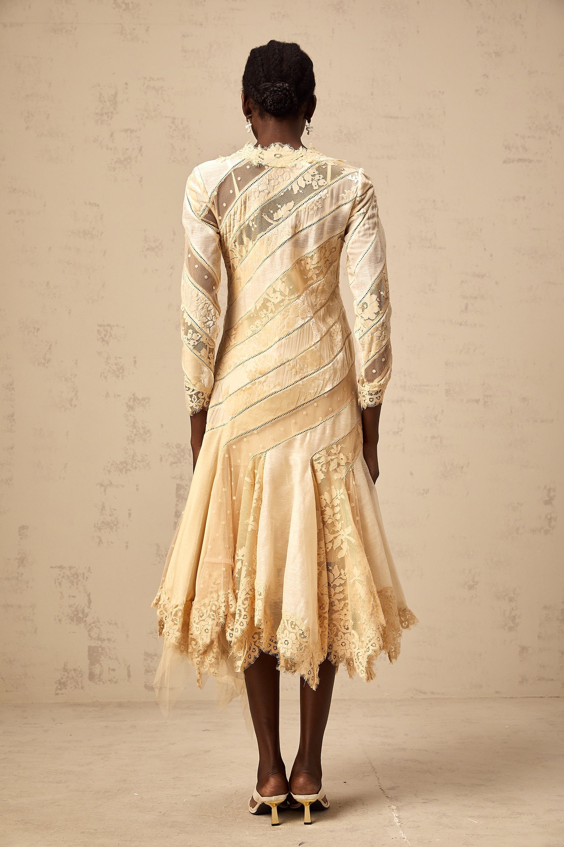 Woman wearing beige midi dress with diagonal stripes and panel details