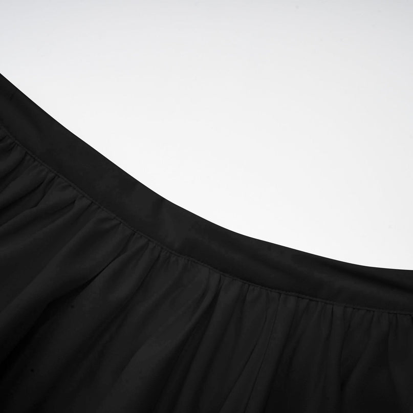 Woman wearing black asymmetric tulle blouse and matching skirt set Andrea style