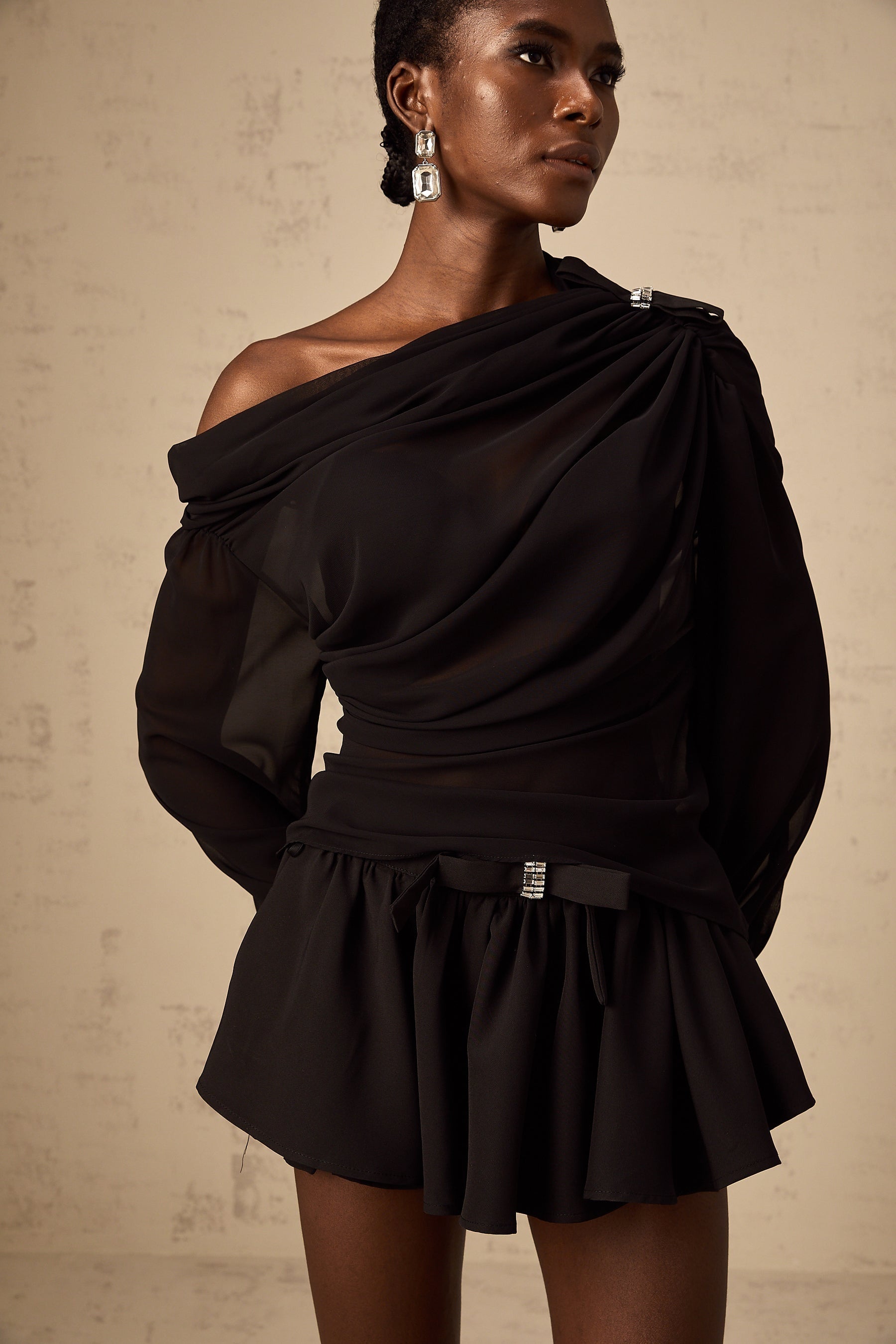 Woman wearing black asymmetric tulle blouse and matching skirt set Andrea style