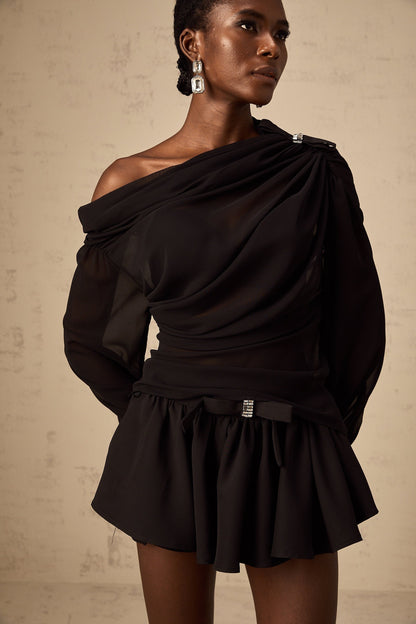 Woman wearing black asymmetric tulle blouse and matching skirt set Andrea style