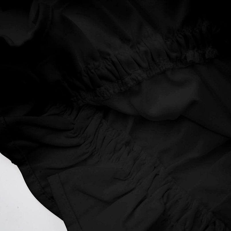 Woman wearing black asymmetric tulle blouse and matching skirt set