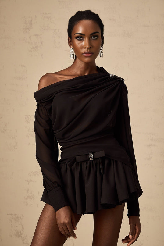 Woman wearing black asymmetric tulle blouse and matching skirt set