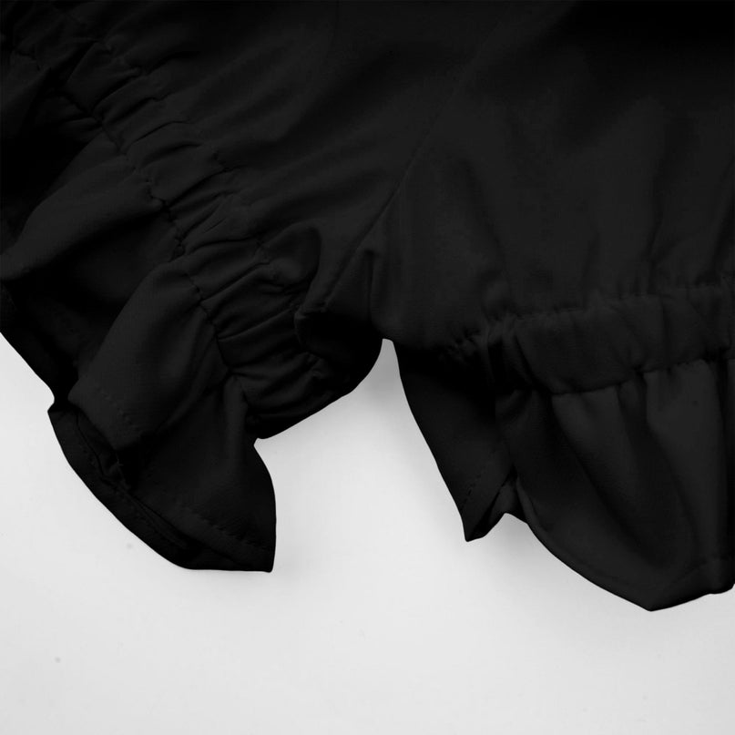 Woman wearing black asymmetric tulle blouse and matching skirt set